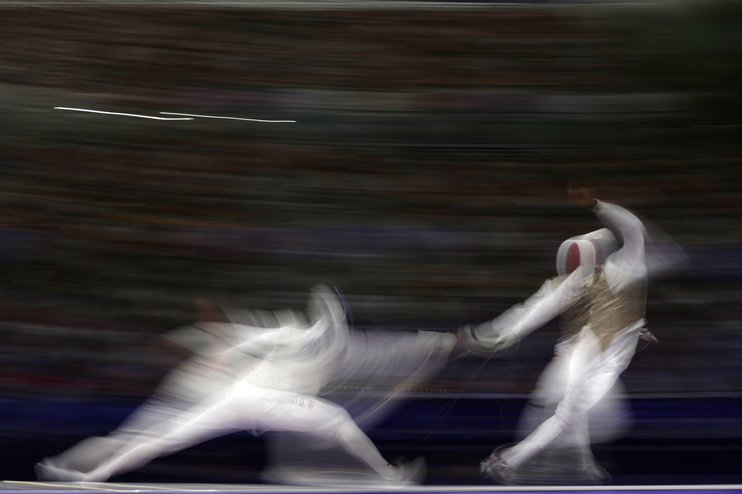 The United States' Nick Itkin competes with France's Enzo Lefort in the men's team foil bronze final match during the 2024 Olympics at the Grand Palais in Paris on August 4, 2024.